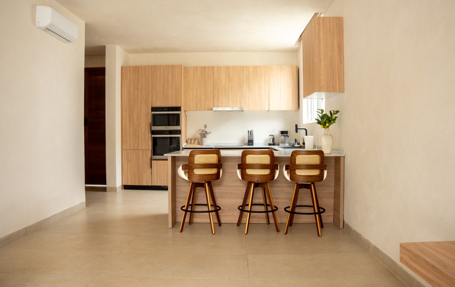 Kitchen and island seating inside a Yves & Saints villa