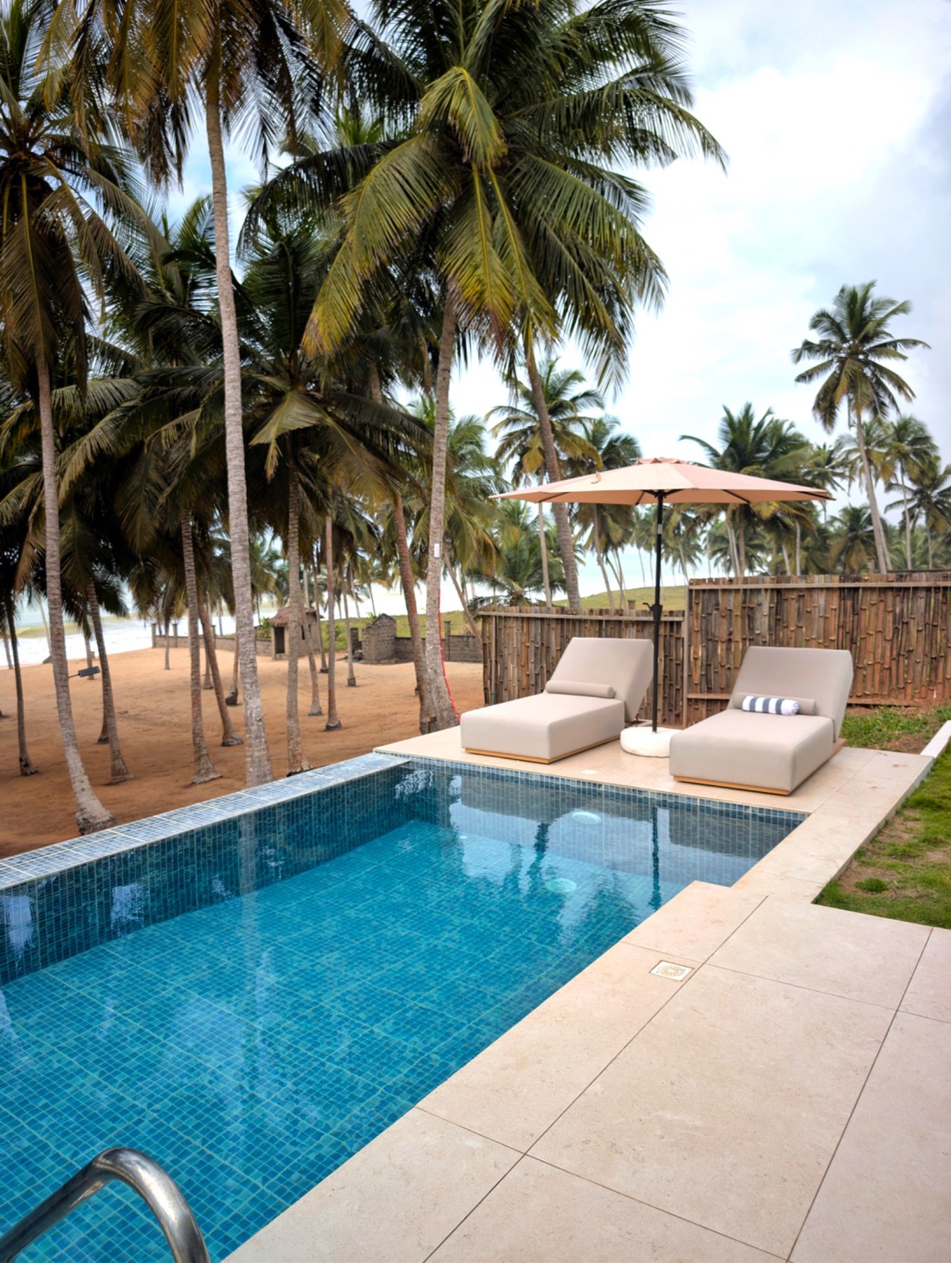 Private villa pool beneath the palms on the Komenda coast