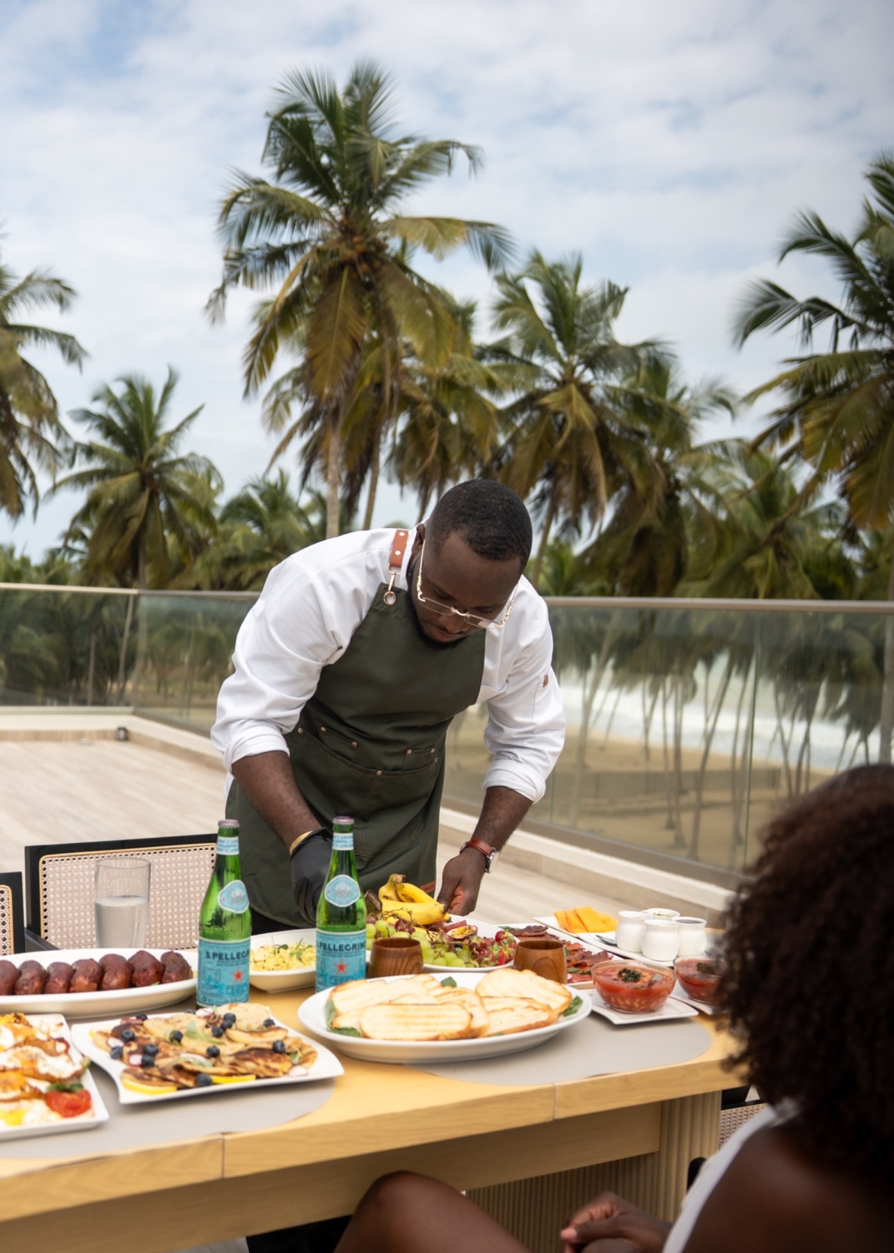 Chef preparing a breakfast spread on the rooftop terrace at Yves and Saints